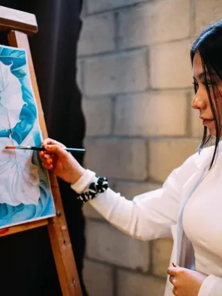 Una alumna del Colegio Horizontes pinta un cuadro sobre un caballete durante una actividad de artes plásticas.