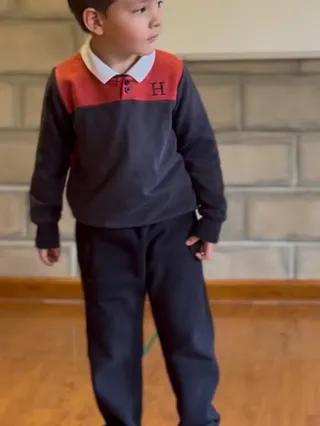 Un niño del nivel inicial del Colegio Horizontes con el buzo institucional en el patio.