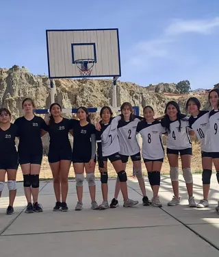 Equipo de vóley del Colegio Horizontes posa en la cancha del colegio, con los cerros de La Paz de fondo.