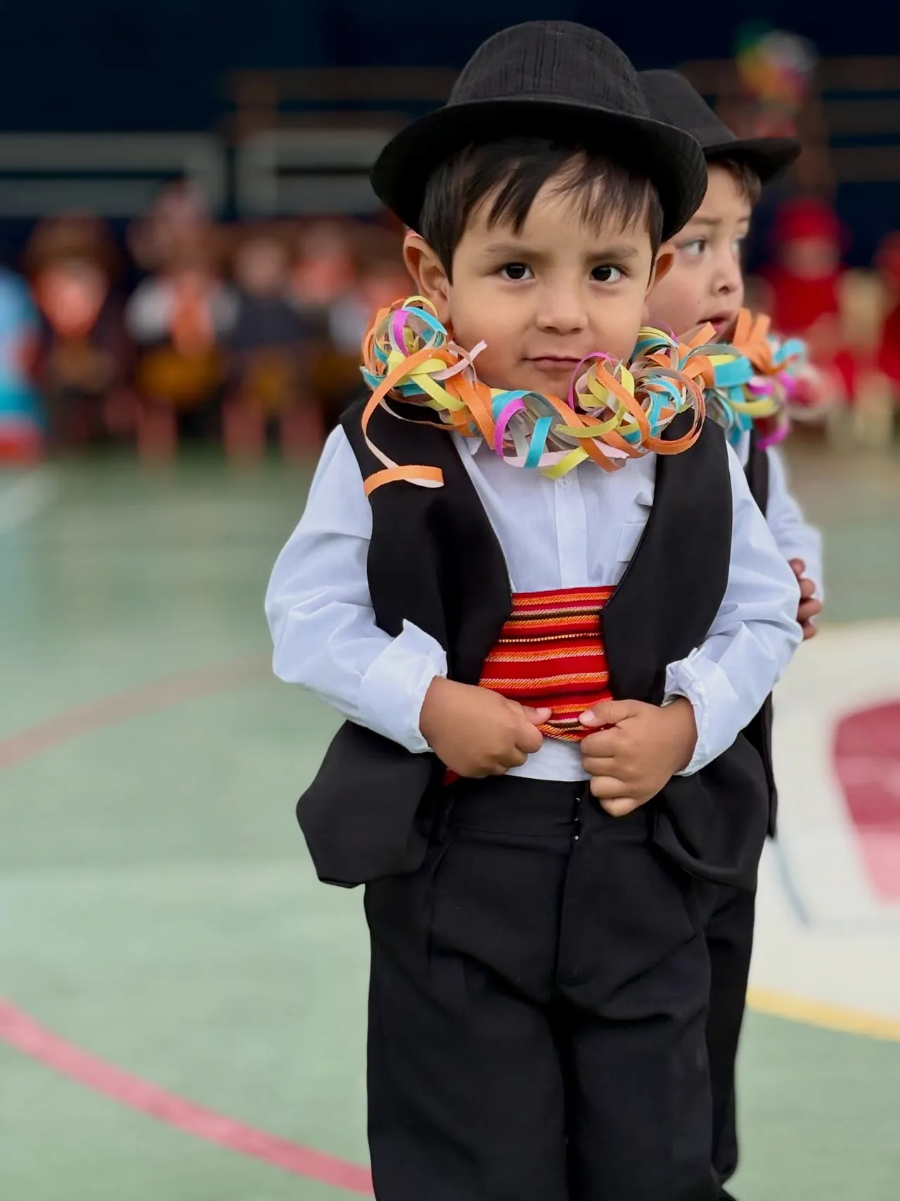 Alumnas de nivel inicial del Colegio Horizontes bailan en fila sobre el piso verde de la cancha techada, en el Día de la Familia por los 35 años del colegio.