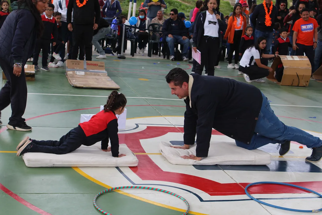 Un padre de familia y su hija, alumna del Colegio Horizontes, realizan un ejercicio de flexiones sobre colchonetas en la cancha techada, durante el Día del Deporte de nivel inicial.