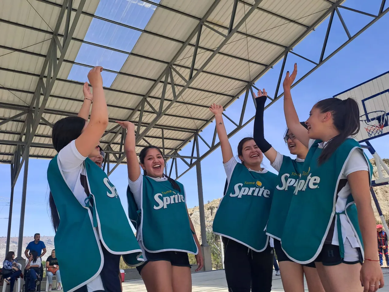 Alumnas del Colegio Horizontes celebran levantando los brazos en la cancha techada, durante el campeonato de voleibol intercursos 2023.